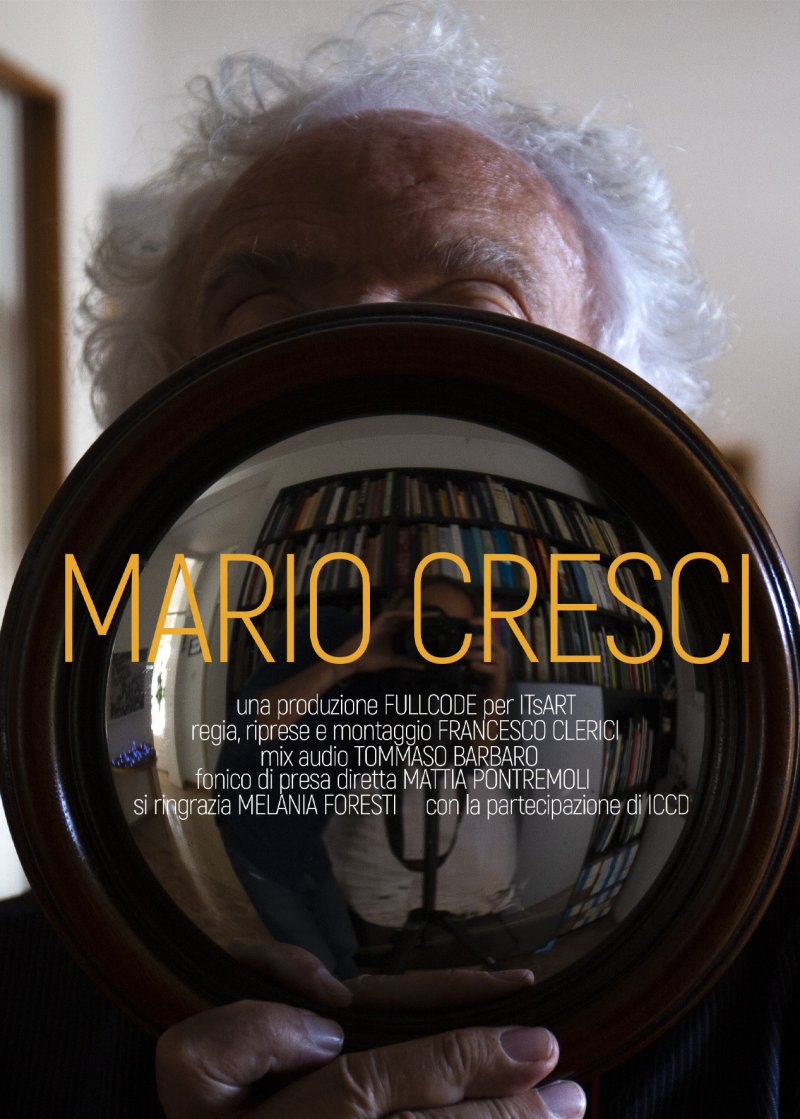 Locandina del film "Mario Cresci" con in primo piano uno specchio tondo che copre il volto di Cresci.